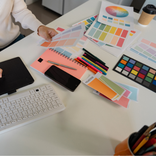 Ett skrivbord med flera färgkartor under grafiskt skapande